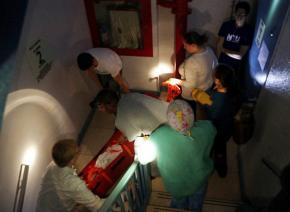 Hospital workers at NYU Langone carry critical patients down a darkened stairwell