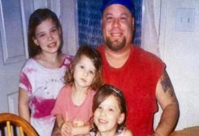 David Silva posing with three of his four children in a family photo